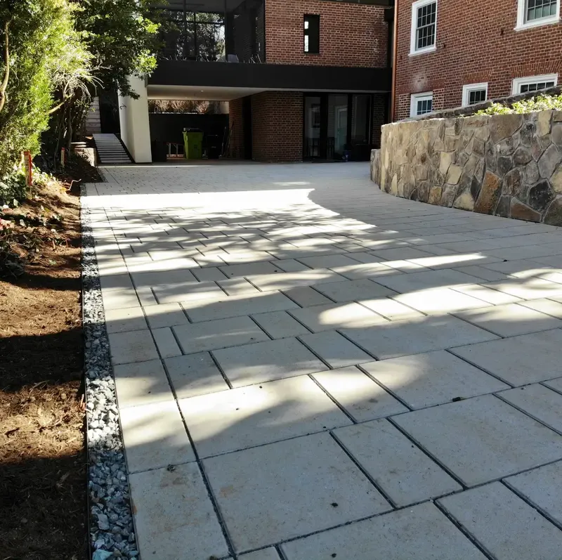 A close-up of a driveway bordered by a thin gravel strip